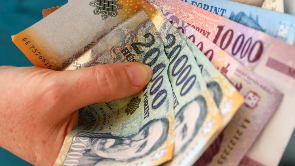 Egy szülő bankjegyet tart a kezében