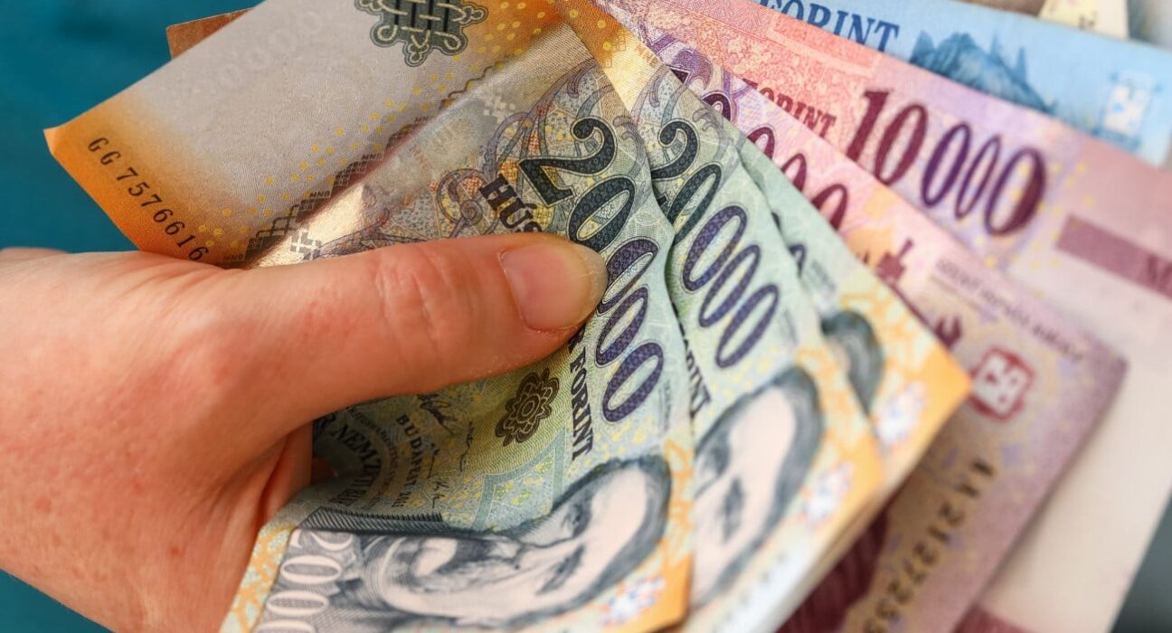 Egy szülő bankjegyet tart a kezében