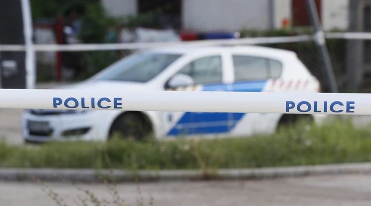 egy rendőrautó parkol a gyilkosság helyszíne mellett