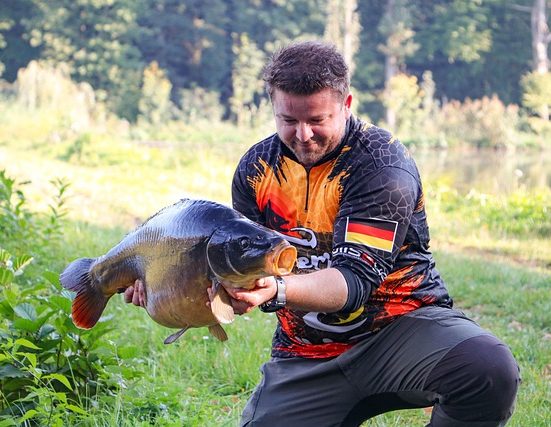Büszkén tartja a kifogott halat a horgász