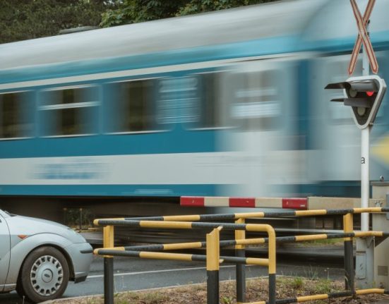 Egy vonat száguld át a vasúti átjáróban