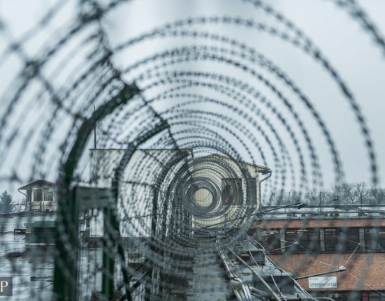 egy fegyház kerítése láthatóm a tetején szögesdróttal