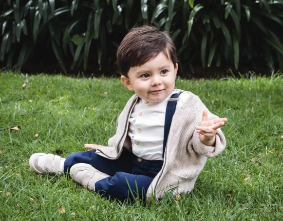 kisfiú játszik a fűben