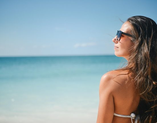 Visszatér a jó idő, lány a tengerparton élvezi a nyarat