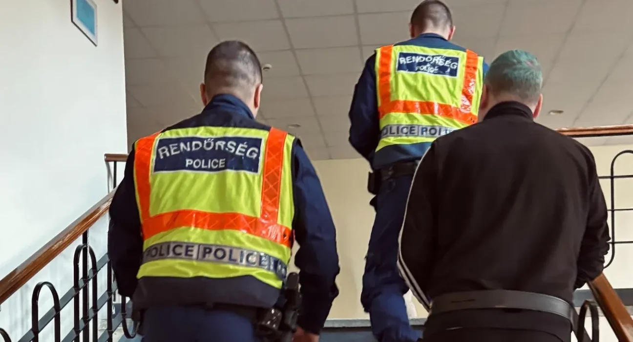 Rendőrök kísérik a bűnözőt a rács mögé
